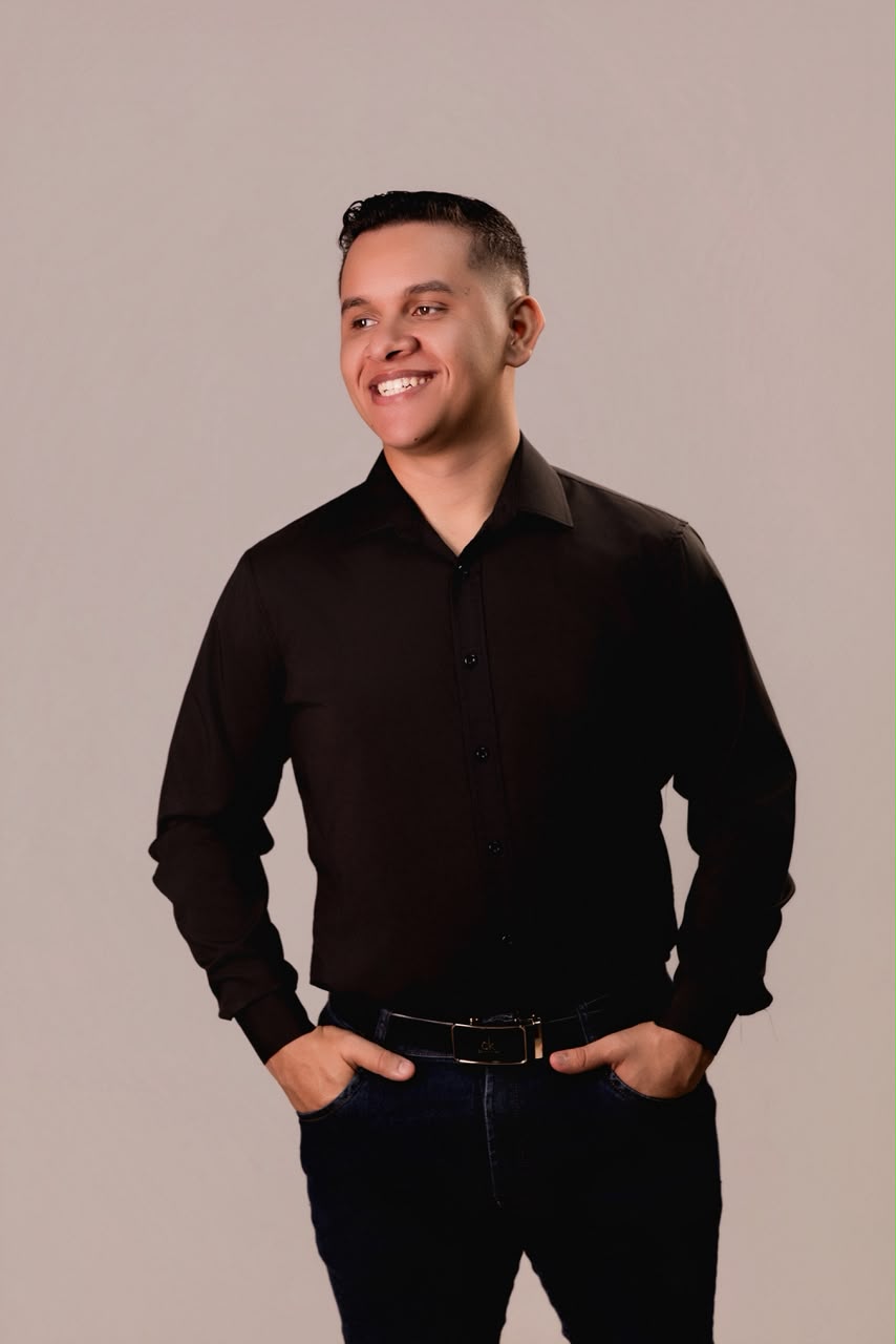 Retrato de Lucas Aquino sorrindo, com camisa escura